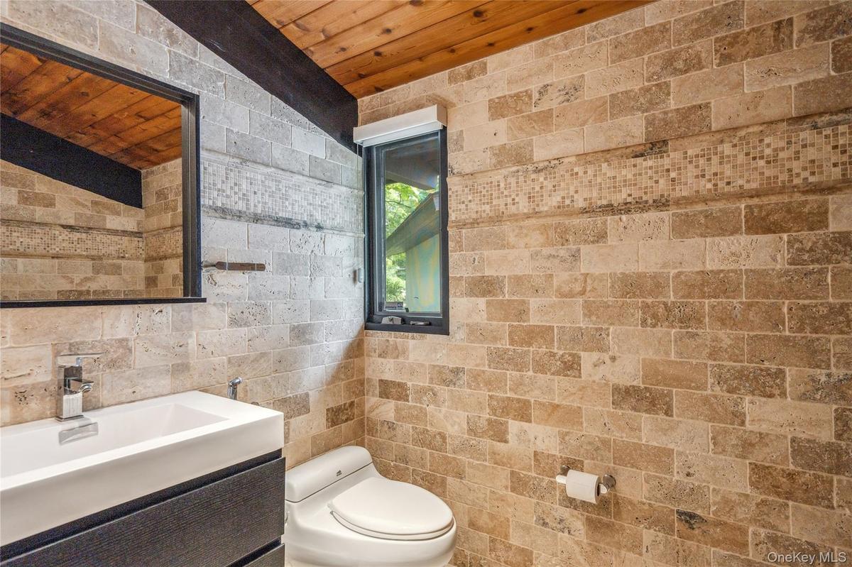 Bathroom featuring wood ceiling, toilet, and vanity
