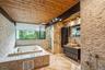 Full bath with wooden ceiling, a tub with jets, vanity, and a stall shower