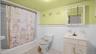 Full bath with tile walls, a wainscoted wall, vanity, shower / tub combo with curtain, and tile patterned floors