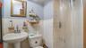 Bathroom featuring curtained shower, tile walls, and a wainscoted wall