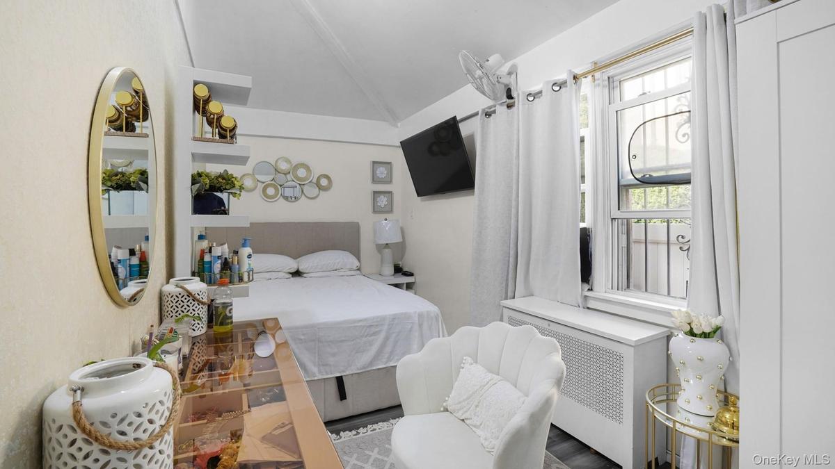 Bedroom featuring radiator heating unit and lofted ceiling