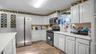 Kitchen featuring appliances with stainless steel finishes, light wood-style floors, and white cabinetry