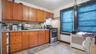 Kitchen with stainless steel range with gas stovetop, light countertops, brown cabinetry, tasteful backsplash, and under cabinet range hood