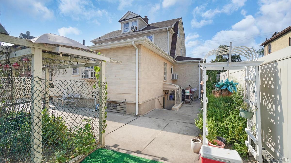 View of side of home featuring a patio area and a shingled roof