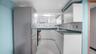 Kitchen featuring backsplash, freestanding refrigerator, dark countertops, gas stove, and open shelves