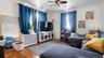 Living area featuring wood-type flooring, a ceiling fan, crown molding, and radiator heating unit