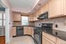 Kitchen featuring light wood-finish cabinetry, black countertops, tiled backsplash, dishwasher, brand new gas range, and recessed lighting.