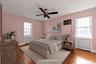 Lower level Bedroom with Hardwood flooring throughout, double closet, and a view of the courtyard.