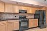 Kitchen featuring light wood cabinetry, dark countertops, tiled backsplash, brand new gas range, brand new LG refrigerator, and recessed lighting.