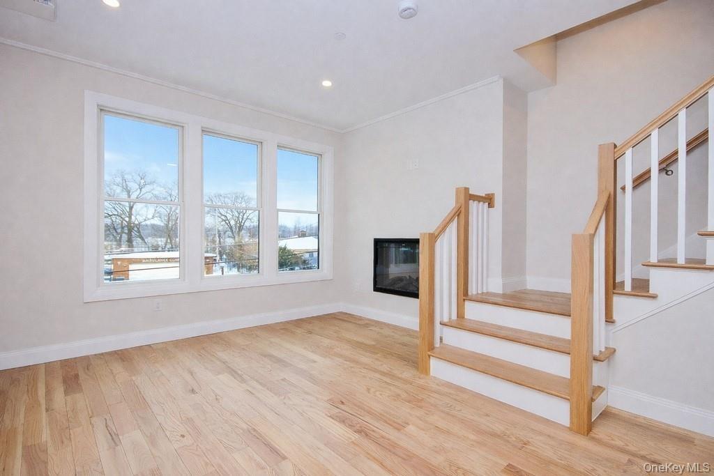 Another view of the living room with stairs leading to the second floor