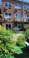 Back of property featuring a balcony and brick siding
