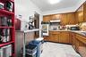 Kitchen with brown cabinets, light countertops, double oven, black microwave, and under cabinet range hood