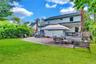 Expansive backyard featuring a lush lawn, a large paver patio, and mature perimeter landscaping