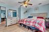 Bedroom featuring wood-finish flooring, a ceiling fan with integrated lighting, and light blue wall tones