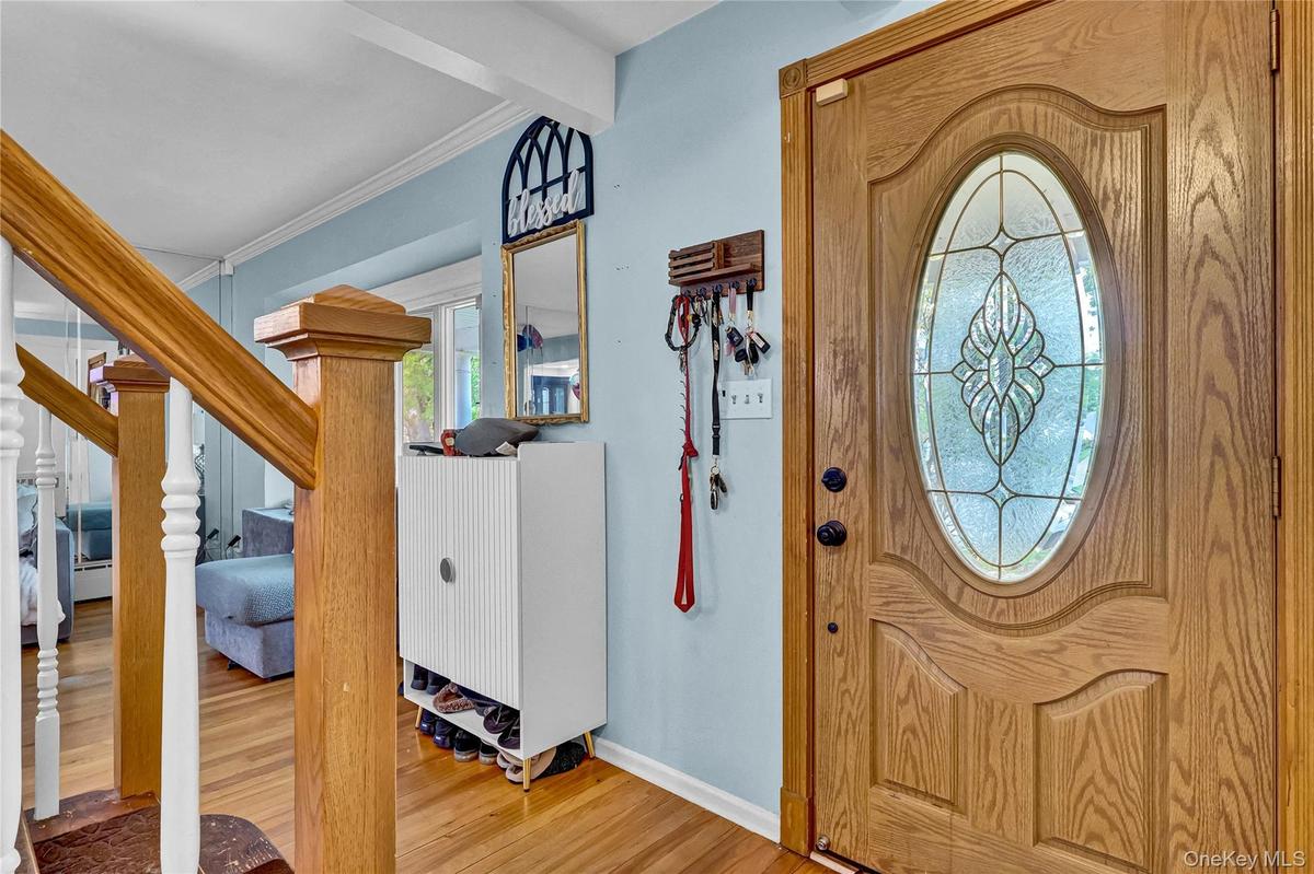 Entryway featuring a decorative wood-finish door with an oval-shaped leaded glass insert