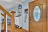 Entryway featuring a decorative wood-finish door with an oval-shaped leaded glass insert