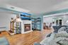 Living area featuring wood-finish flooring, a white mantel fireplace, and a light blue accent wall