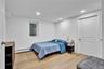 Bedroom featuring wood-finish flooring, recessed lighting, and a white paneled door with an arched top panel