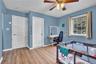 Room featuring wood-finish flooring, two paneled doors, and a window with natural light