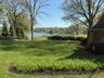 Expansive green lawn with established trees and waterfront access
