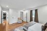 Bright room featuring recessed lighting, hardwood flooring, white paneled doors, and a window with dark drapery