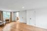 Spacious room featuring wood-finish flooring, recessed lighting, and a white barn door