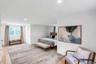 Spacious room featuring light wood-finish flooring, recessed lighting, and white walls