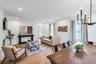 Open-concept living and dining area featuring light wood-finish flooring, recessed lighting, and a modern candelabra chandelier