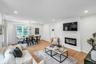 Open-concept living and dining area featuring light wood flooring, recessed lighting, a built-in linear electric fireplace, and a dining space with a 