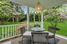 Covered porch with white railings and an overhead woven pendant light