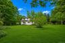 Spacious green lawn with mature trees and a central ornamental shrub