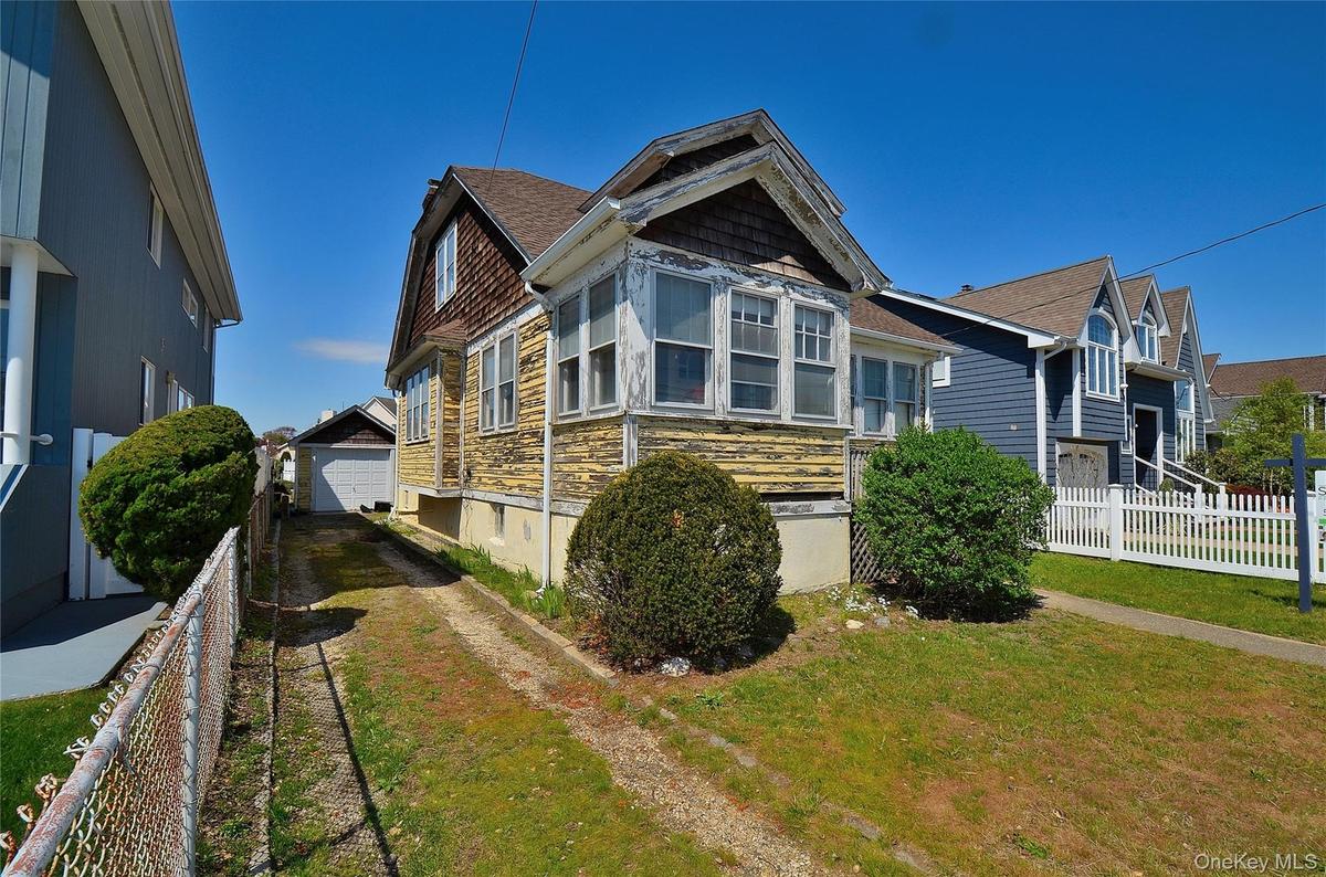 Exterior featuring a gabled roofline, detached garage