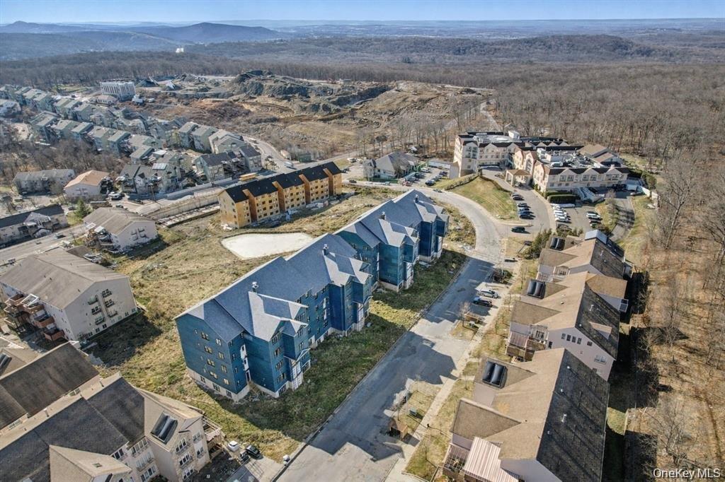 Aerial view of a heavily wooded area and apartment complex / building
