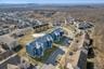 Aerial view of a heavily wooded area and apartment complex / building