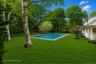 Expansive rear yard featuring a rectangular inground swimming pool rendering with a light-colored coping