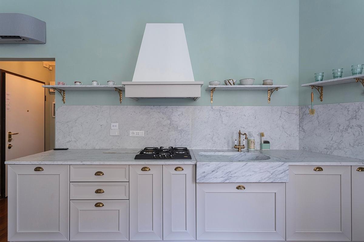 Kitchen with marble countertop, marble shelving, and elegant full-wood cabinetry