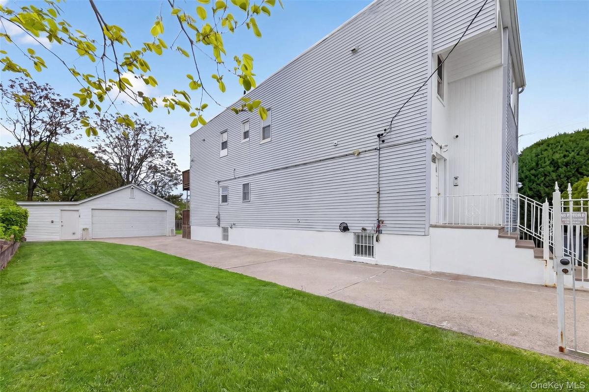 Expansive green lawn with a detached two-car garage and additional storage space