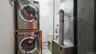 Dedicated laundry area featuring stacked front-loading washer and dryer units