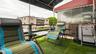Outdoor balcony featuring artificial turf flooring and a black metal railing
