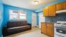 Open-concept living space featuring a full kitchen with wood cabinetry, a mosaic tile backsplash, and a white oven/range