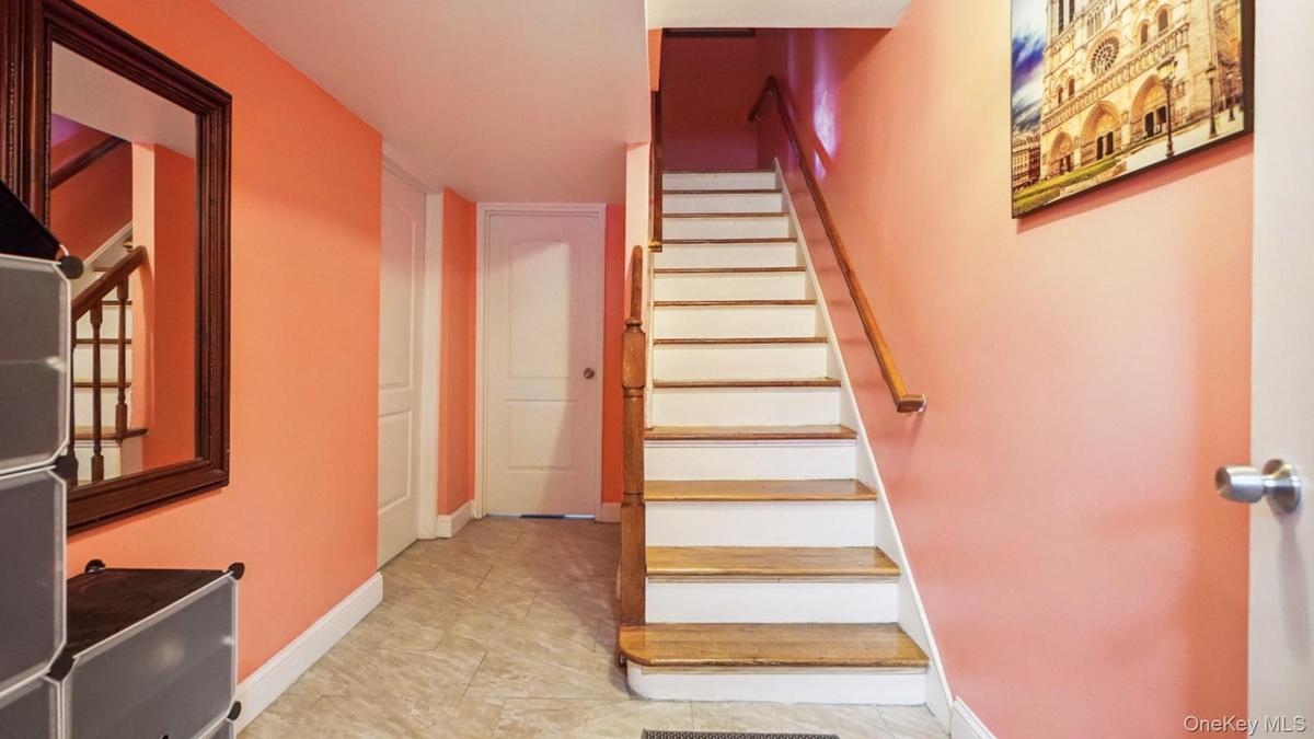 Wood-finish staircase with white risers and a light wood handrail