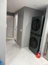 Washroom with stacked washer / drying machine and baseboards