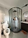 Bathroom featuring tile walls, vanity, a marble finish shower, and tile patterned floors