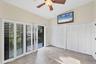 Second floor bedroom with vaulted ceilings and balcony