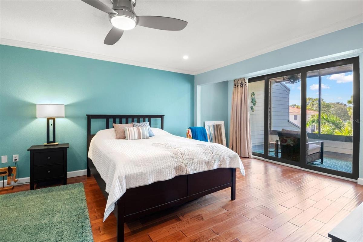 Primary suite with sliding doors to private screen enclosed balcony