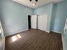 bedroom # 2 first floor featuring wood-finish flooring, two windows providing natural illumination, and a ceiling fan