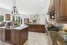 Spacious kitchen featuring two large islands with integrated wine storage and a sink