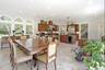 Spacious kitchen and dining area featuring light-toned tile flooring, recessed lighting, and a bay window with arched transoms