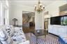 Living area featuring dark wood-finish flooring, white trim, and a decorative chandelier