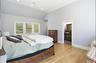 Vaulted ceiling room featuring light wood-finish flooring and a trio of windows